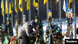 Женщина на могиле погибшего сына на каладбище в городе Ирпень (Киевская область)