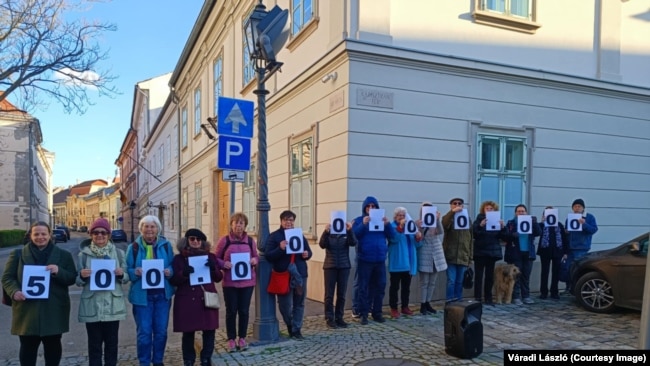 "Ötszázmilliárd forint az szinte elképzelhetetlenül sok pénz"– jelentette ki V. Naszályi Márta az Úri utca 72. alatti MNB-s épületnél. Ennyivel gazdálkodott az alapítványok vagyonát kezelő OPTIMA Befektetési-, Ingatlanhasznosító és Szolgáltató Zrt. (OPTIMA Befektetési Zrt.)
