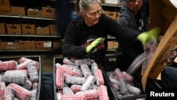 Волонтеры сортируют замороженный говяжий фарш в благотворительном продовольственном магазине для неимущих в Коммерс-Сити. Штат Колорадо, 31 октября 2025 года