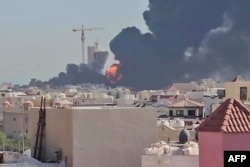 A plume of smoke and flames billows over the town of Mangaf, south of Kuwait City, after an Iranian missile attack on July 18.