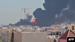 A plume of smoke and flames billows over the town of Mangaf, south of Kuwait City, after an Iranian missile attack on July 18.