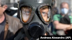 Un protestatar purtând o mască de gaz în fața Ministerului Mediului din țară în timpul unui protest privind clima și antipoluare în București, România, 4 martie 2020.