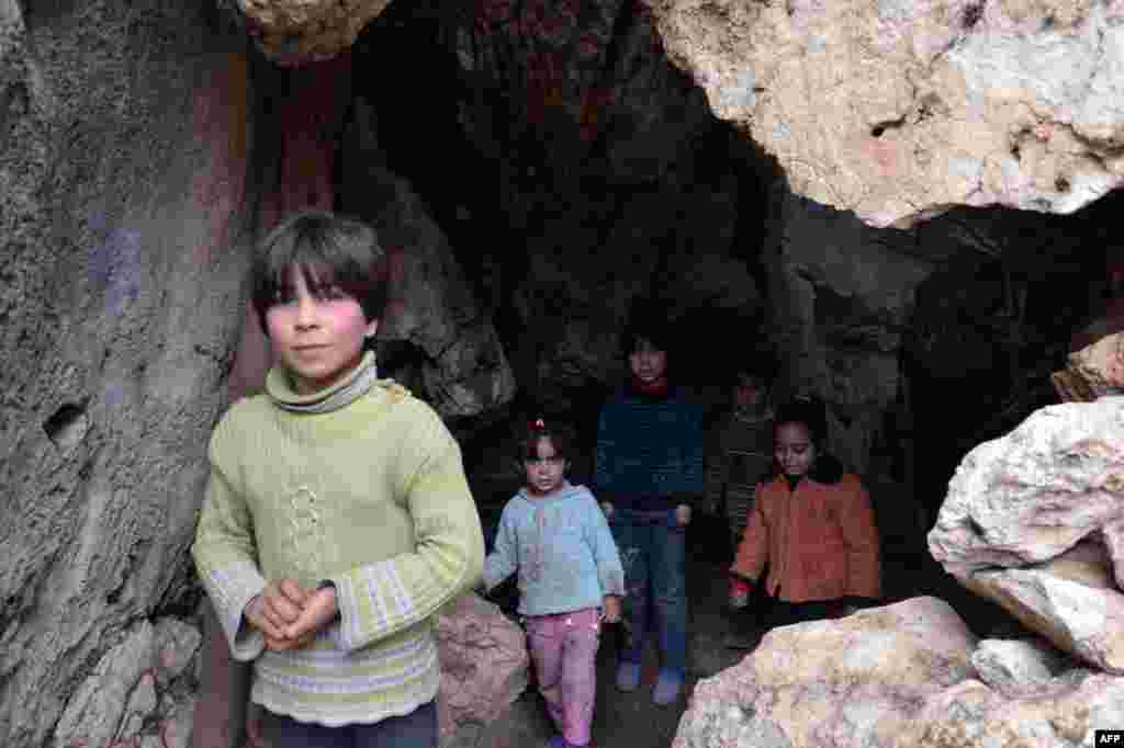 Suriyanın şimalında Ain al-Zarka şəhərini h&ouml;kumət q&uuml;vvələri bombalayarkən qa&ccedil;ıb mağarada gizlənən uşaqlar. 21 yanvar 2013