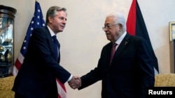 Secretarul de stat al SUA, Antony Blinken, dă mâna cu președintele palestinian Mahmoud Abbas, în Amman, Iordania, vineri, 13 octombrie 2023.