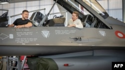 Președintele ucrainean Volodimir Zelenski (stânga) și premierul danez Mette Frederiksen stau într-un avion de luptă F-16 în hangarul bazei aeriene Skrydstrup din Vojens, nordul Danemarcei, pe 20 august.