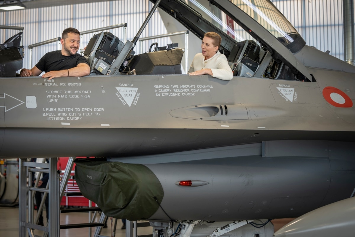 Ukrainian President Volodymyr Zelensky (left) and Danish Prime Minister Mette Frederiksen sit in the cockpit of an F-16 fighter jet in a hangar at Skrydstrup Air Base in Vojens, Denmark, August 20, 2023