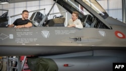Ukrajinski predsjednik Volodimir Zelenski (L) i danska premijerka Mette Frederiksen sjede u borbenom avionu F-16 u hangaru baze Skrydstrup u Vojensu, sjeverna Danska, 20. 8. 2023.
