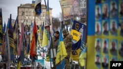 Locuitorii Kievului vizitează un memorial improvizat pentru soldații ucraineni și străini în Piața Independenței din Kiev - 24 februarie 2026