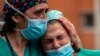 اسپانیا؛ دو پرستار در سوگ همکار خود که بر اثر ابتلای به ویروس کرونا جان باخته است، می‌گریند 
