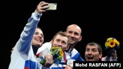 Russian fencer Sergei Bida (left) with teammates after winning a silver medal in the men's epee event at the Tokyo Olympic Games in 2021. 