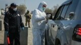 Kyrgyzstan - Bishkek - Generic - COVID-19 - coronavirus - A security officer in a protective mask checks the temperature of a passenger following the outbreak of a new coronavirus, at an away in Bishkek, a region bordering Sokuluk.