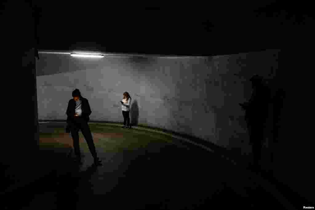 Ukrainians take shelter inside an underground parking lot during Russian drone and missile strikes in Kyiv.
