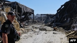 A police officer walks at the site of a shopping mall damaged following a Russian strike in Kryviy Rih on August 22.