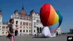 Aktivisti podižu veliko srce duginih boja ispred zgrade mađarskog parlamenta u Budimpešti, 8. jula 2021, u znak protesta protiv usvojenog zakona za kojeg tvrde da diskriminiše i marginalizuje LGBT osobe. 