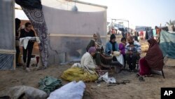 Жер которгон палестиналык Абу Жарад үй-бүлөсү менен Газанын түштүгүндөгү Муваси аймагындагы убактылуу качкындар лагеринде нан бышырууда. 1-январь, 2024-жыл