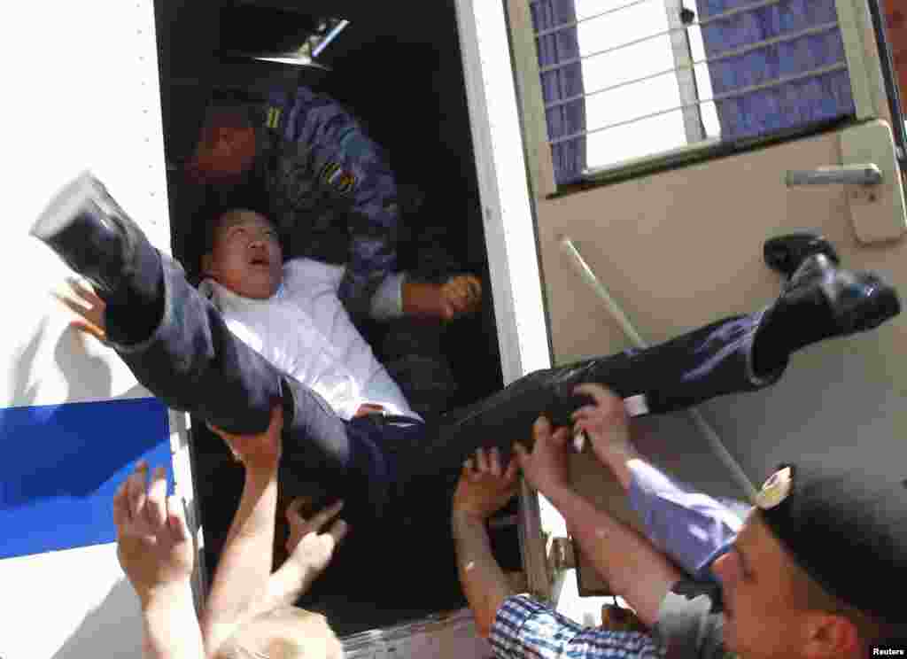 Police force gay-rights activist Daniel Choi into a police vehicle as they detain him near the Kremlin during an unsanctioned gay-pride parade in central Moscow on May 29, 2011.