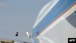 U.S. President Barack Obama walks up the stairs of Air Force One, which is equipped with everything from a mobile hospital to a gourmet kitchen. It can also protect the president against almost any threat, except, it would appear, the common cold.