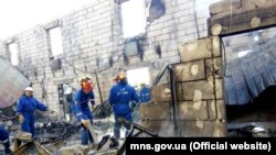 Ukrainian firefighters search through the rubble at an assisted-living facility for old people, where at least 17 died when a fire ripped through the building in the early hours of the morning on May 29. 