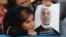 A supporter of Hassan Rohani holds a campaign poster of the candidate during a rally in Ahvaz in western Iran.