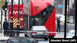 Полицаец стои покрај автомобилот кој се урна во безбедносна бариера кај британскиот Парламент. 14.08.2018