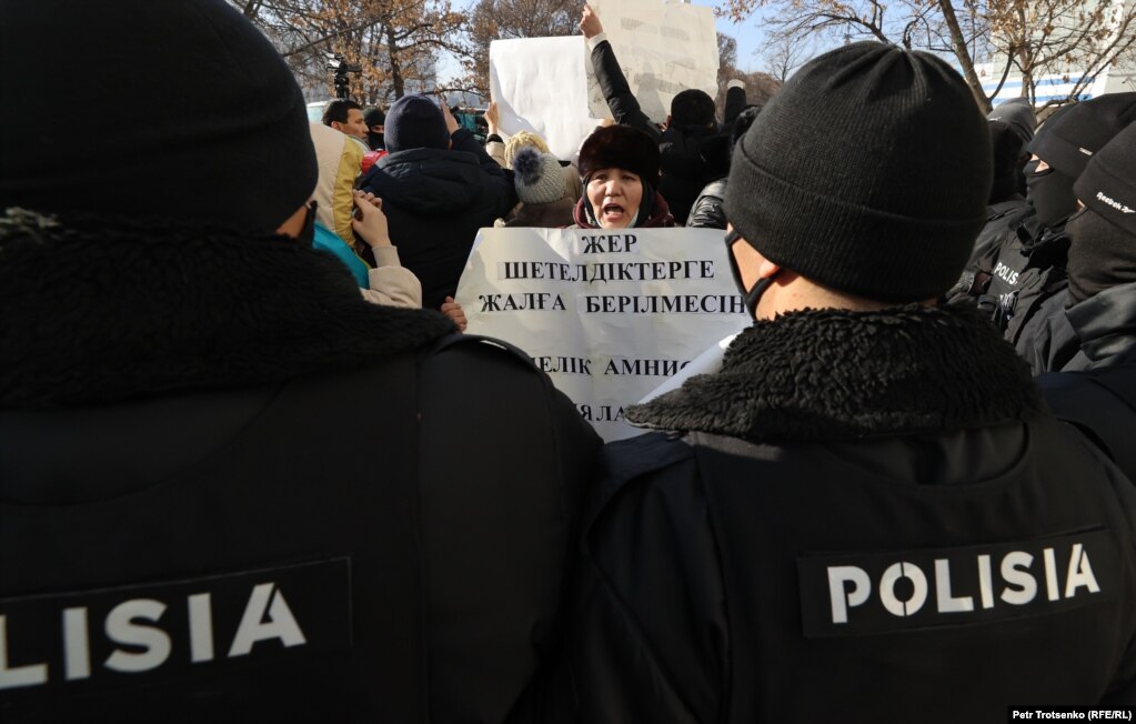 Гражданская активистка в окружении сотрудников полиции. Алматы, 10 января 2021 года.