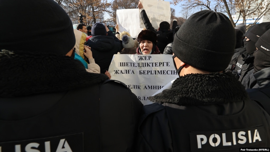 Гражданская активистка в окружении сотрудников полиции. Алматы, 10 января 2021 года.