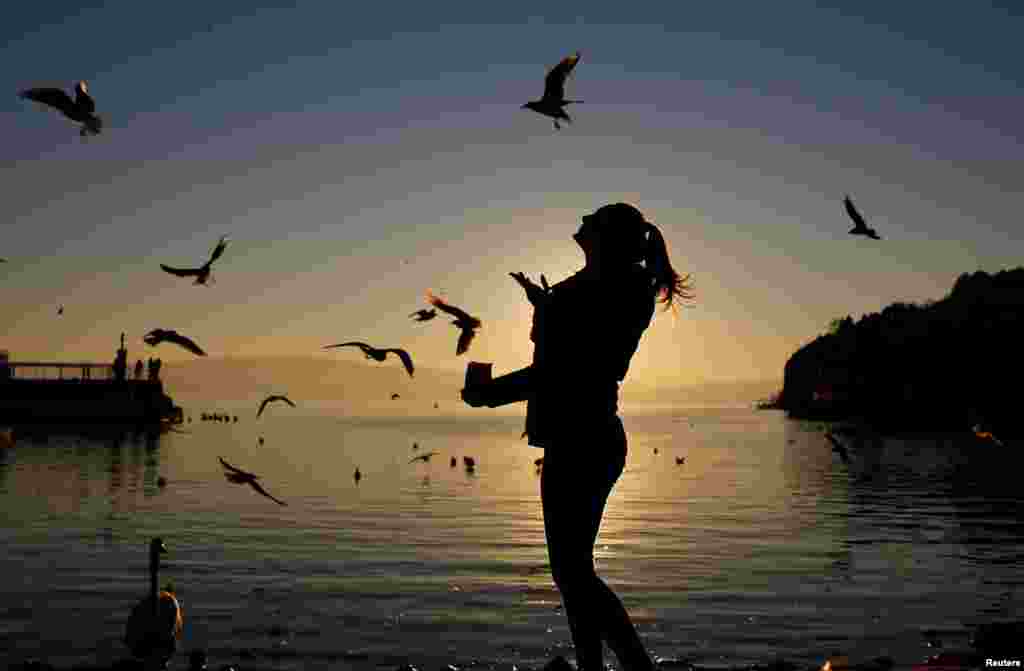 A girl feeds gulls on the shores of Ohrid Lake in Macedonia. (Reuters/Ognen Teofilovski)