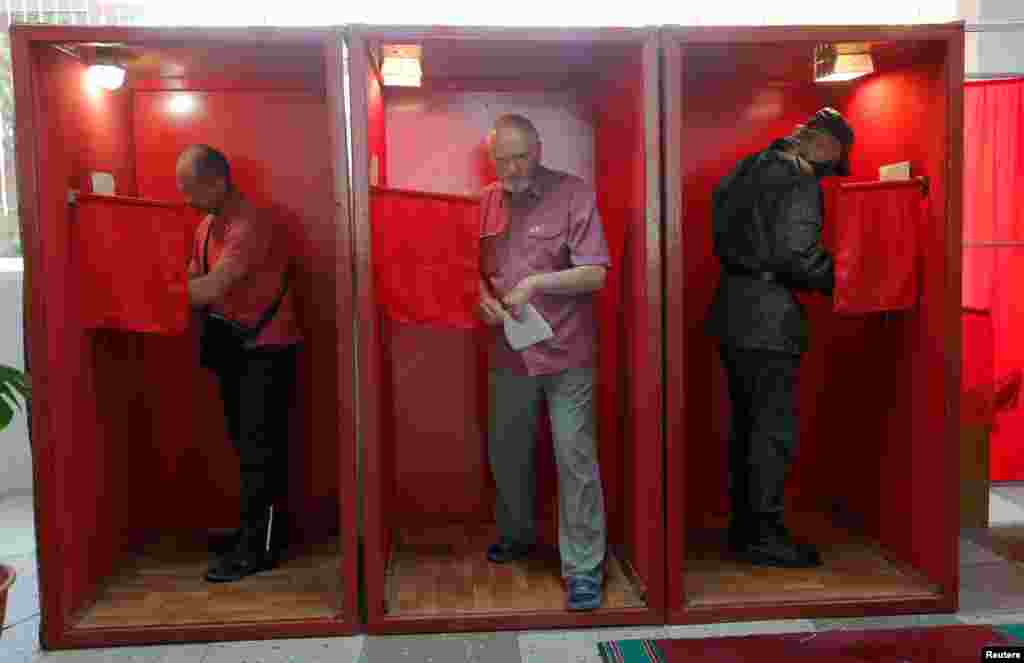 People fill in their ballots at a polling station in Minsk.