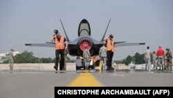 Personalul militar american pregătind de decolare un Lockheed Martin F-35 fighter la demonstrația aeriană de la Le Bourget în apropiere de Paris, 27 iunie 2017. (Photo by CHRISTOPHE ARCHAMBAULT / AFP)