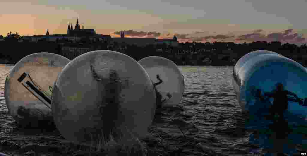 Tourists play in Zorb balls on the Vltava River during a hot summer evening in central Prague. (epa/Filip Singer)