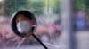 A man wearing a face mask is seen, reflected in his electric bike's rearview mirror, on a street after the lockdown was lifted in Wuhan, capital of Hubei province and China's epicentre of the novel coronavirus disease (COVID-19) outbreak