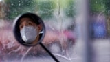 A man wearing a face mask is seen, reflected in his electric bike's rearview mirror, on a street after the lockdown was lifted in Wuhan, capital of Hubei province and China's epicentre of the novel coronavirus disease (COVID-19) outbreak