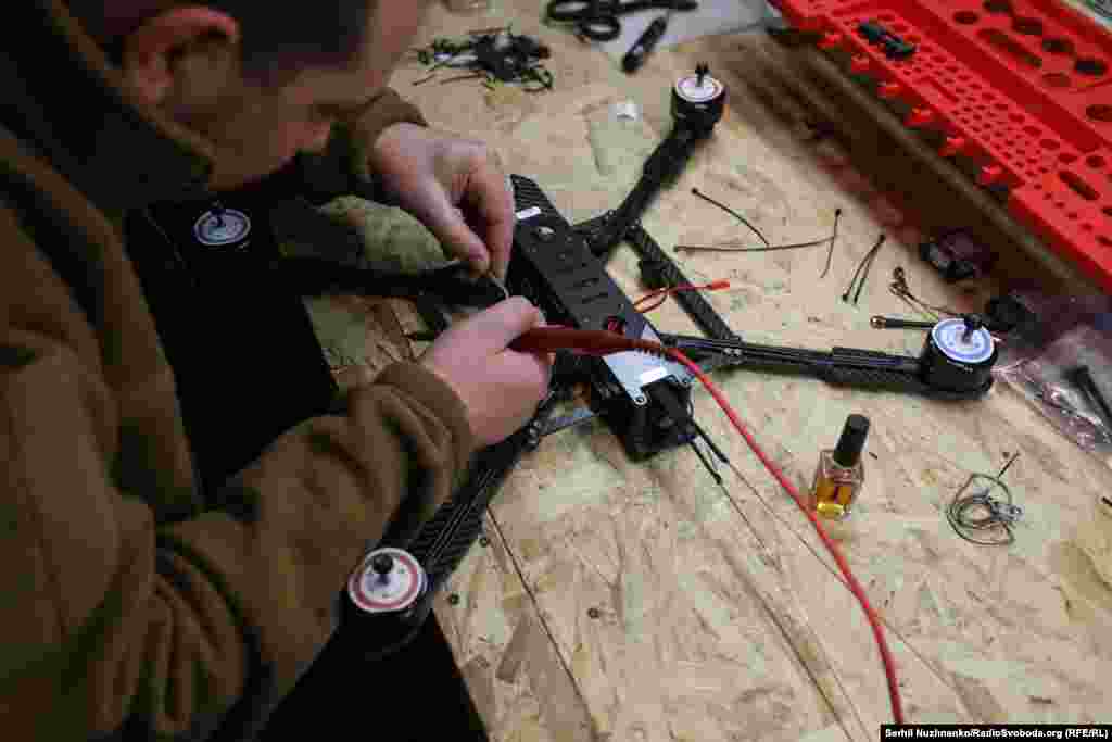 Один із військових паяє контакти до FPV-дрона