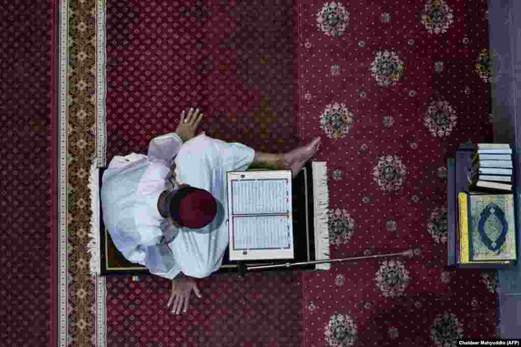 Një besimtar mysliman lexon Kuranin në xhamin Al Makmur në Banda Açe të Indonezisë më 13 prill, 2021.&nbsp; 