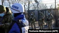 Ukrainian border guards look on as OSCE observers cross a checkpoint between Ukrainian government-controlled territory and separatist areas in the town of Shchastya in the Luhansk region in November.