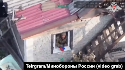 Кадр з відео Міноборони РФ, який начебто демонструє присутність російських військових в Добропіллі. Однак навіть російські мілблогери звернули увагу на неприродні рухи прапора, припустивши використання штучного інтелекту