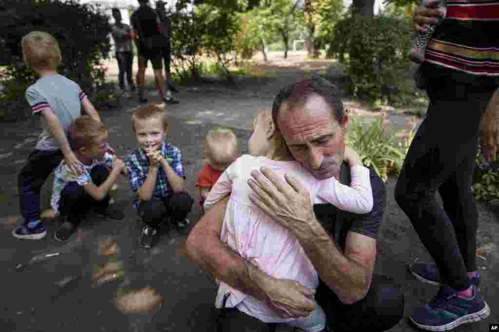  A father hugs his daughter, his other children nearby, as they wait for evacuation in Pokrovsk, Donetsk region, Ukraine. &nbsp; 