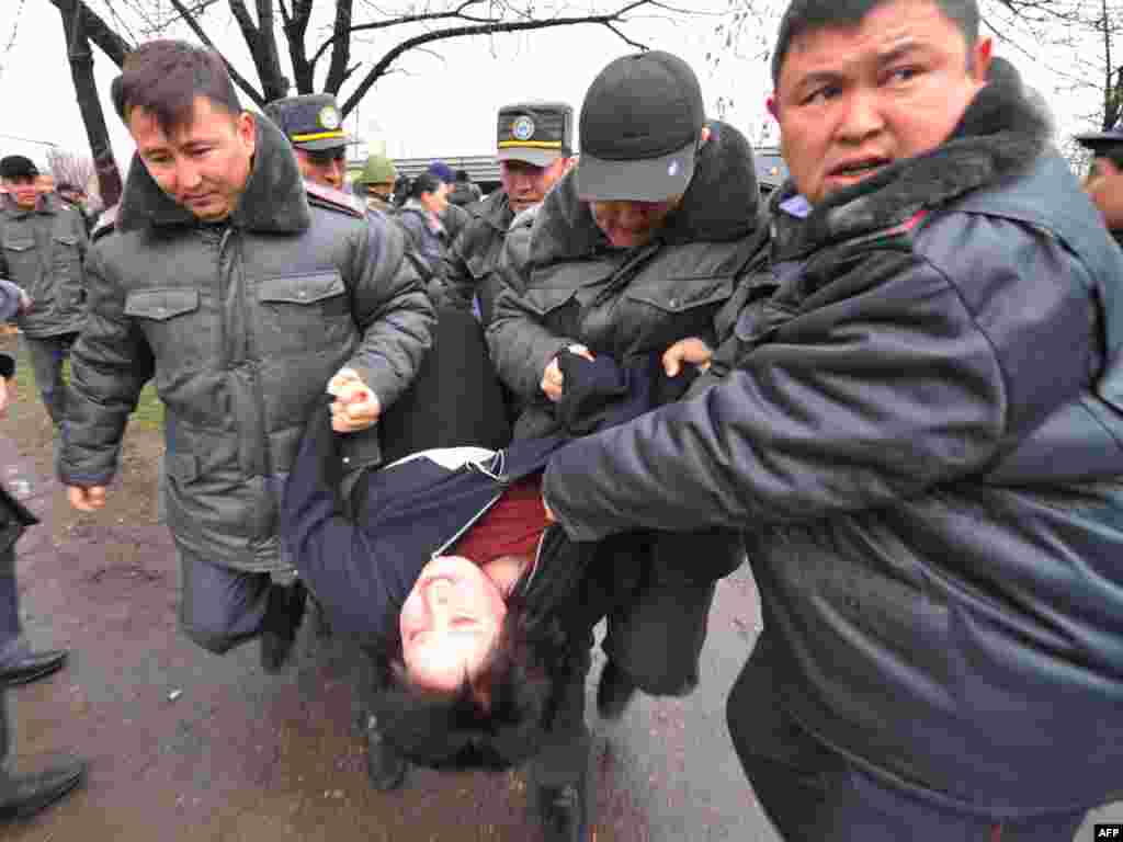 An opposition supporter is carried by police.