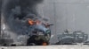 UKRAINE – This photograph taken on February 27, 2022 shows a Russian Armoured personnel carrier (APC) burning next to unidentified soldier's body during fight with the Ukrainian armed forces in Kharkiv