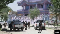 Security officials stand guard in front of the house of Arsala Rahmani, senior peace negotiator, in Kabul, after his murder.