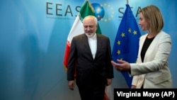 European Union High Representative Federica Mogherini, right, greets Iran's Foreign Minister Mohammad Javad Zarif prior to a meeting in Brussels on Monday, March 16, 2015.