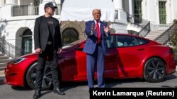 Američki predsjednik Donald Trump razgovara s medijima pored izvršnog direktora Tesle Elona Muska, s Teslinim automobilom u pozadini, u Bijeloj kući, mart 2025.
