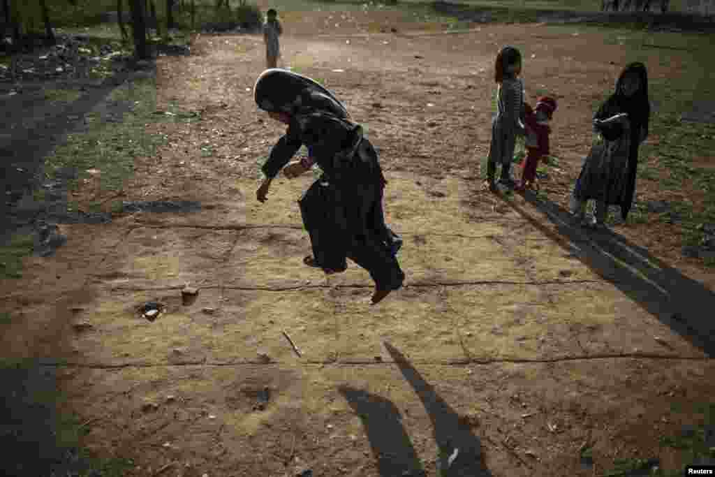 A girl jumps as she plays hopscotch on the outskirts of Islamabad, Pakistan. (Reuters/​Zohra Bensemra)