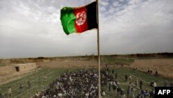 The Afghan national flag is hoisted during an official flag-raising ceremony on February 25 in Marjah, a former insurgent stronghold.