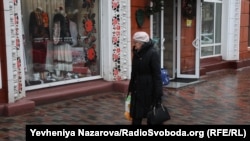 Перехожа розглядає вітрину магазину з національним вбранням в центрі Дніпра