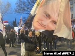 Portreti i presidentit rus, Vladimir Putin, bartet nga një protestues në Beograd më 17 mars 2026.