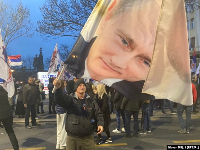 Portreti i presidentit rus, Vladimir Putin, bartet nga një protestues në Beograd më 17 mars 2026.