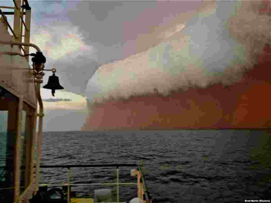 A dramatic cloud formation tinged with red dust travels across the Indian Ocean near Onslow on Australia&#39;s west coast on January 9.