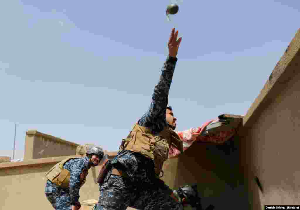 An Iraqi federal policeman throws a hand grenade during clashes with Islamic State (IS) fighters in western Mosul, Iraq, on April 29, 2017.