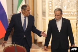 Russian Foreign Minister Sergei Lavrov and Iranian Foreign Minister Abbas Araqchi arrive for a press conference after meeting in Tehran on October 19.